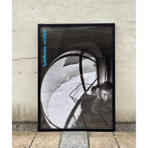 Official Bauhaus-Archiv Berlin poster featuring Marianne Brandt's iconic 1928 metallic sphere self-portrait reflection, available unframed or framed in a black solid wooden frame.