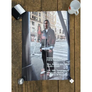 Promotional exhibition poster for thisisneverthat FW19 featuring a male model in a flag jacket standing on a New York City street corner framing industrial steel architecture.