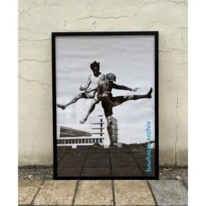 Official Bauhaus-Archiv Berlin poster featuring a dynamic 1920s black and white photograph of figures jumping in the air in front of Bauhaus architecture, available unframed or framed in a black solid wooden frame.