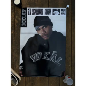 Official vintage music poster of hip-hop star Nelly wearing a black VOKĀL hoodie, skull cap, and his signature cheek bandage, with a black-and-white photo film strip at the top, measuring 61x91.5cm.