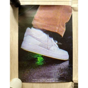 Official 2022 Slam Jam x Nike Air Force 1 promotional poster photographed by Julian Klincewicz featuring a macro close-up shot of a white sneaker stepping on a wet surface with warm earthy tones.