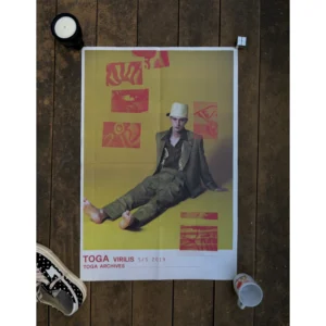 Official double-sided TOGA S/S 2019 lookbook art poster, featuring a sitting male model in green suit for TOGA VIRILIS on a yellow backdrop on Side A, and a sculptural collage of buckle boots and PULLA bags on Side B, measuring 80.5x53cm.