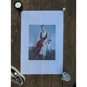Official double-sided TOGA S/S 2023 fashion poster shot by Liv Liberg, featuring a close-up portrait of a woman in a low-cut black dress on Side A, and the same woman seated with red striped tights beside a toddler on Side B, measuring 80.5x53cm.