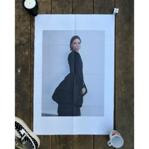 Official double-sided TOGA S/S 2023 fashion poster shot by Zoë Ghertner, featuring a portrait of a woman in a black avant-garde volume dress in side profile on Side A, and with arms raised in frontal view on Side B, measuring 80.5x53cm.