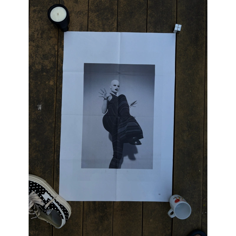 toga ss2023 3 2 Official double-sided TOGA S/S 2023 fashion poster shot by Camille Vivier, featuring black-and-white high-fashion portraits of a bald model in avant-garde poses and striped bodywear, measuring 80.5x53cm.
