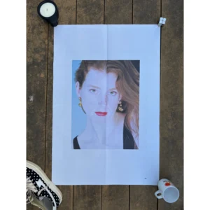 Official double-sided TOGA S/S 2023 fashion poster shot by Liv Liberg, featuring an elderly woman with round glasses in a red floral dress on Side A, and a close-up portrait of a red-haired woman wearing statement earrings on Side B, measuring 80.5x53cm.